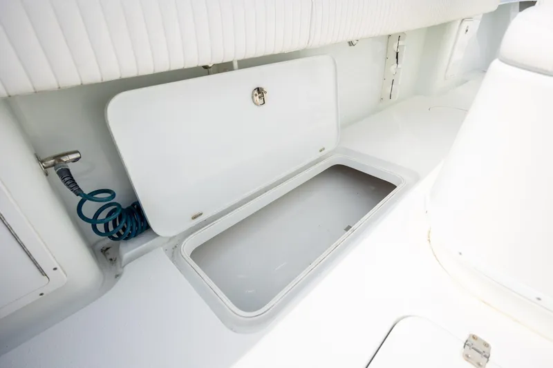 Slide: The Image of Storage compartment on a 2013 Yellowfin 32 Offshore boat, featuring a coiled hose. - 23