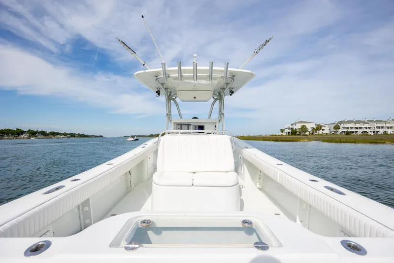Slide: The Image of 2013 Yellowfin 32 Offshore boat on calm water, showcasing spacious deck and seating. - 25