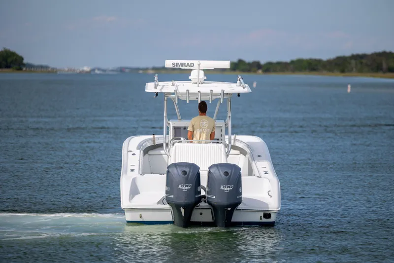 Slide: The Image of 2013 Yellowfin 32 Offshore boat cruising on calm waters, rear view. - 4