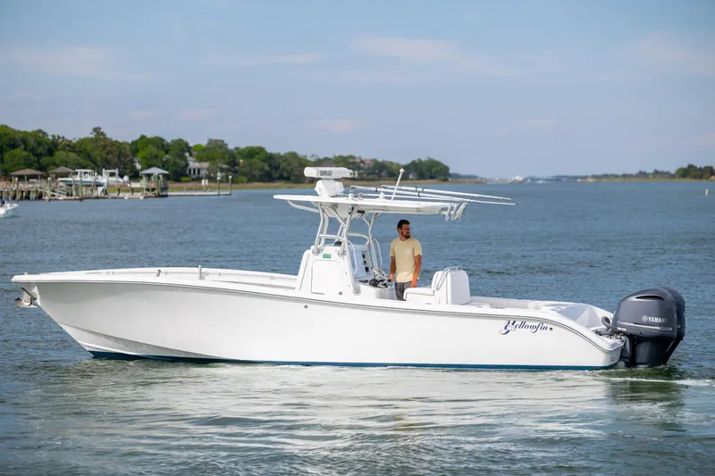 Slide: The Image of 2013 Yellowfin 32 Offshore boat on calm water with a person onboard. - 6