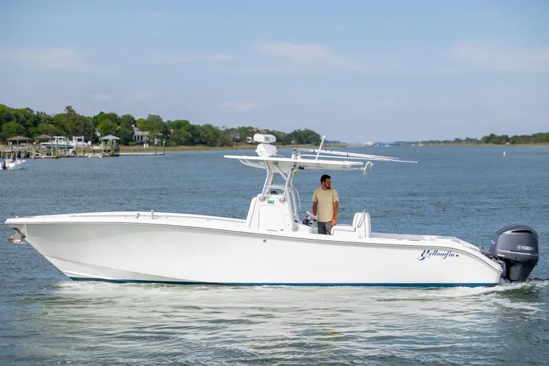 Slide: The Image of 2013 Yellowfin 32 Offshore boat cruising on a calm river with a person onboard. - 7