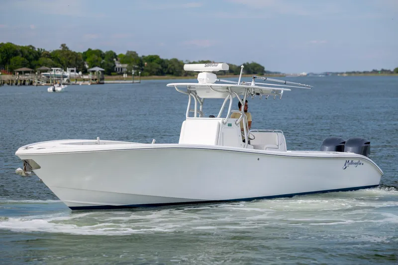 Slide: The Image of 2013 Yellowfin 32 Offshore boat cruising on calm waters near a scenic shoreline. - 8