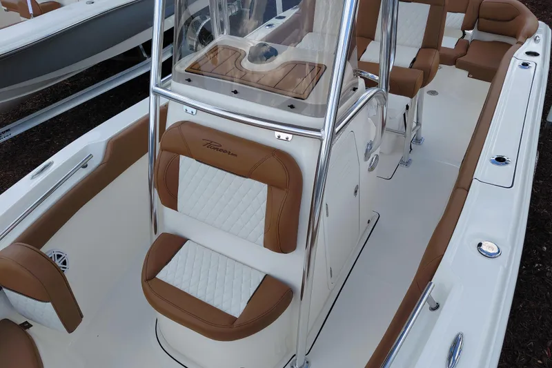 Slide: The Image of 2026 Pioneer 202 Islander boat interior with tan and white seating, sleek design. - 14