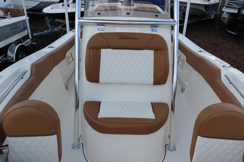Slide: The Image of 2026 Pioneer 202 Islander boat interior with tan and white cushioned seating. - 15