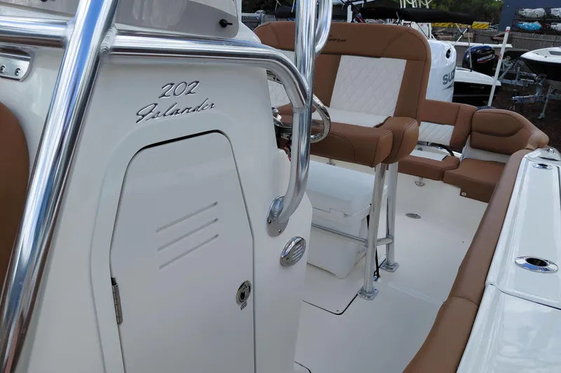 Slide: The Image of 2026 Pioneer 202 Islander boat interior with tan seating and chrome details. - 21