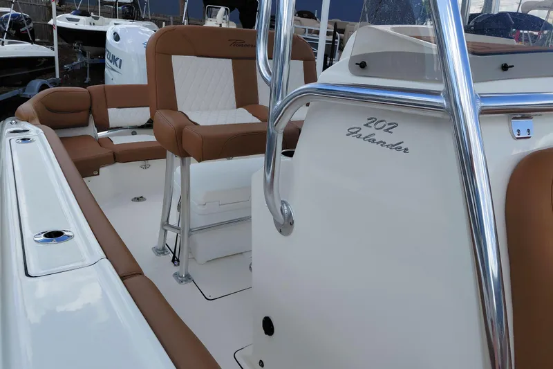 Slide: The Image of 2026 Pioneer 202 Islander boat interior with brown and white seating, chrome details. - 22