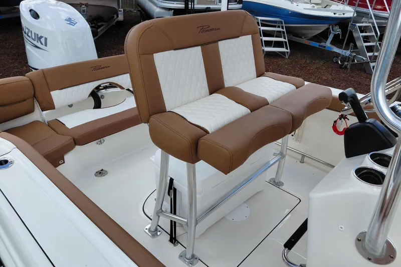 Slide: The Image of 2026 Pioneer 202 Islander boat interior with tan and white seating, featuring a Suzuki outboard motor. - 23