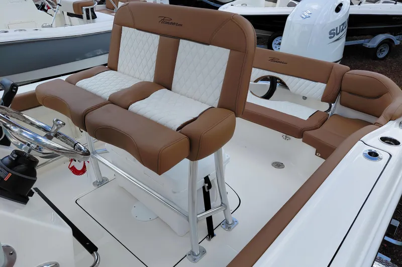Slide: The Image of 2026 Pioneer 202 Islander boat interior with brown and white seating, steering wheel, and controls. - 24