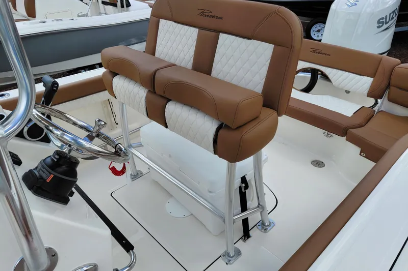Slide: The Image of 2026 Pioneer 202 Islander boat interior with brown and white seating, steering wheel, and controls. - 25