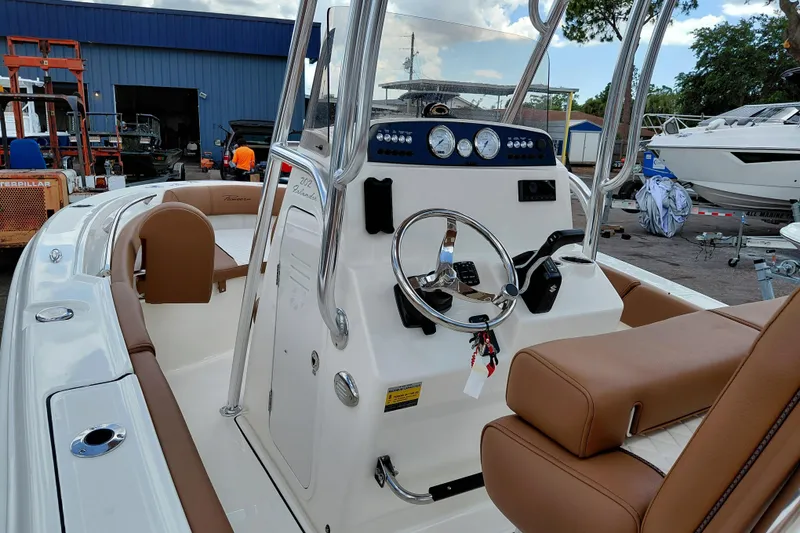 Slide: The Image of 2026 Pioneer 202 Islander boat interior with steering console and brown seating. - 28