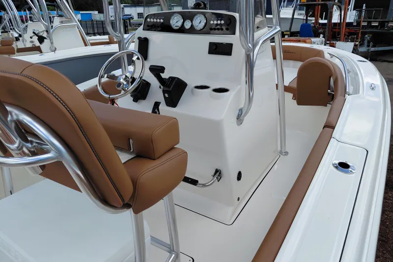 Slide: The Image of 2026 Pioneer 202 Islander boat interior with brown seating and modern dashboard controls. - 29