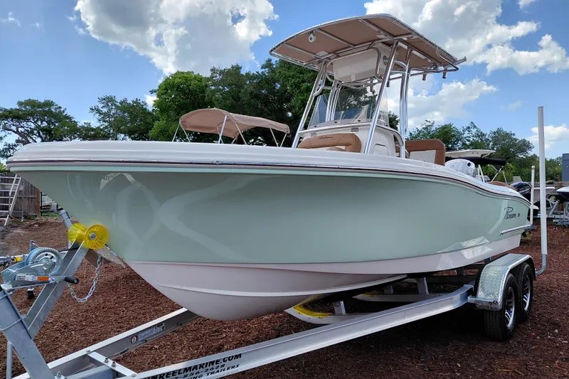 Slide: The Image of 2026 Pioneer 202 Islander boat on trailer, under a clear blue sky with clouds. - 3