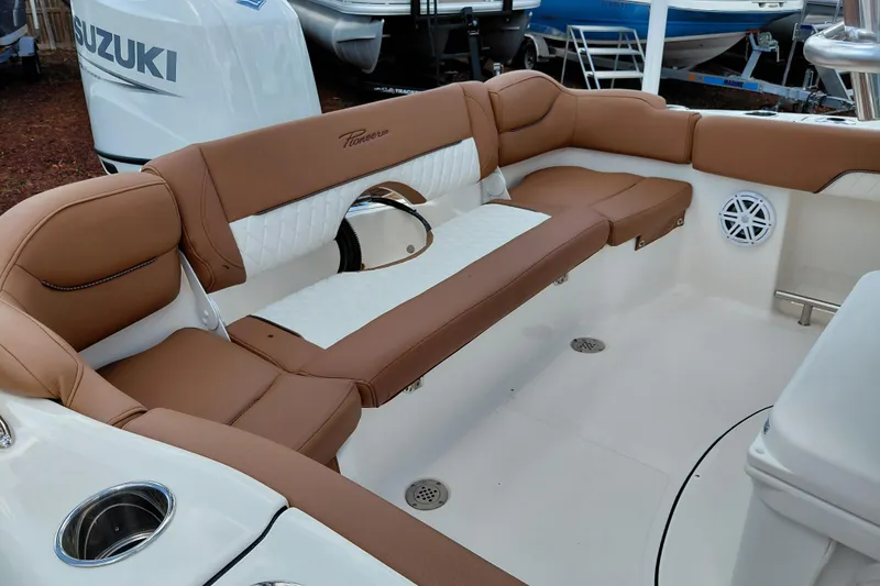 Slide: The Image of 2026 Pioneer 202 Islander boat interior with brown and white seating, Suzuki engine visible. - 31