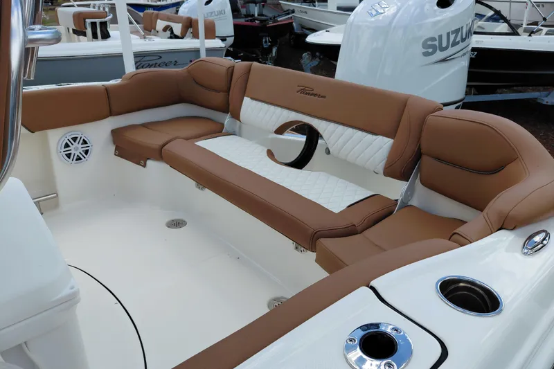 Slide: The Image of 2026 Pioneer 202 Islander boat interior with brown and white cushioned seating. - 32