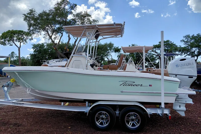 Slide: The Image of 2026 Pioneer 202 Islander boat on trailer, parked outdoors under a partly cloudy sky. - 4
