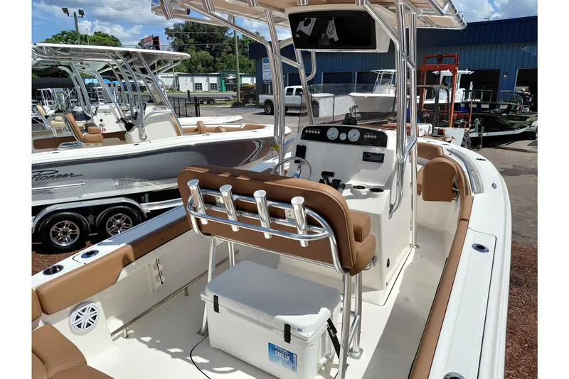 Slide: The Image of 2026 Pioneer 202 Islander boat with tan seating, center console, and rod holders at a dealership. - 42