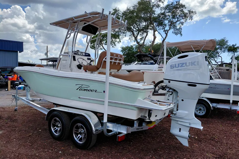 Slide: The Image of 2026 Pioneer 202 Islander boat with Suzuki engine on a trailer, outdoors. - 5