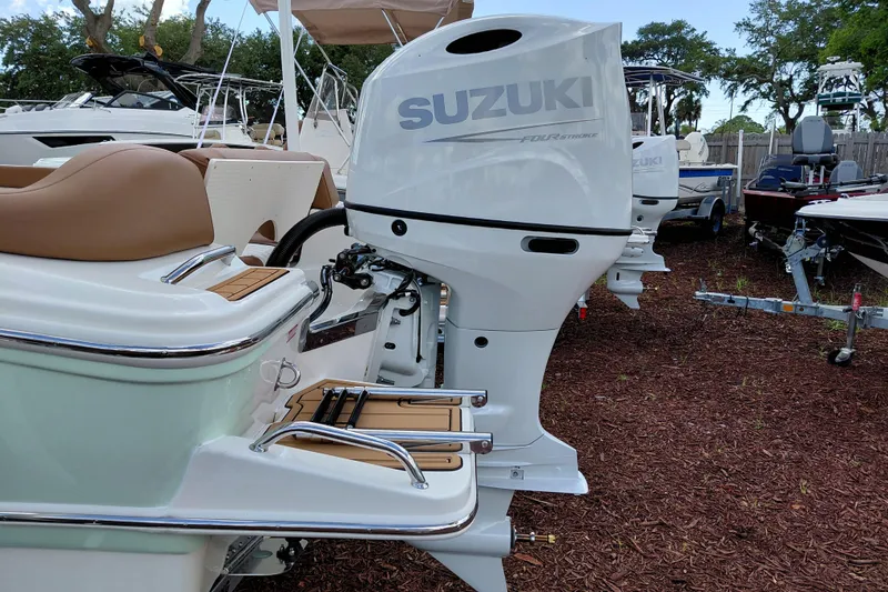 Slide: The Image of 2026 Pioneer 202 Islander boat with Suzuki outboard motor in a marina setting. - 7