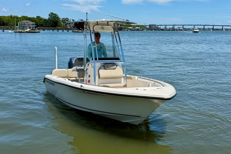 Slide: The Image of 2023 Key West 189 FS boat on calm water with a person at the helm. - 2