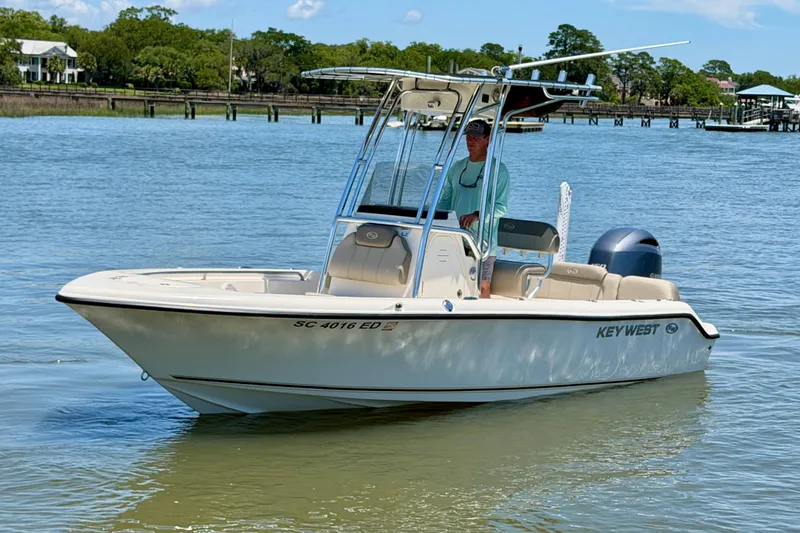 Slide: The Image of 2023 Key West 189 FS boat on calm water with a person at the helm. - 3