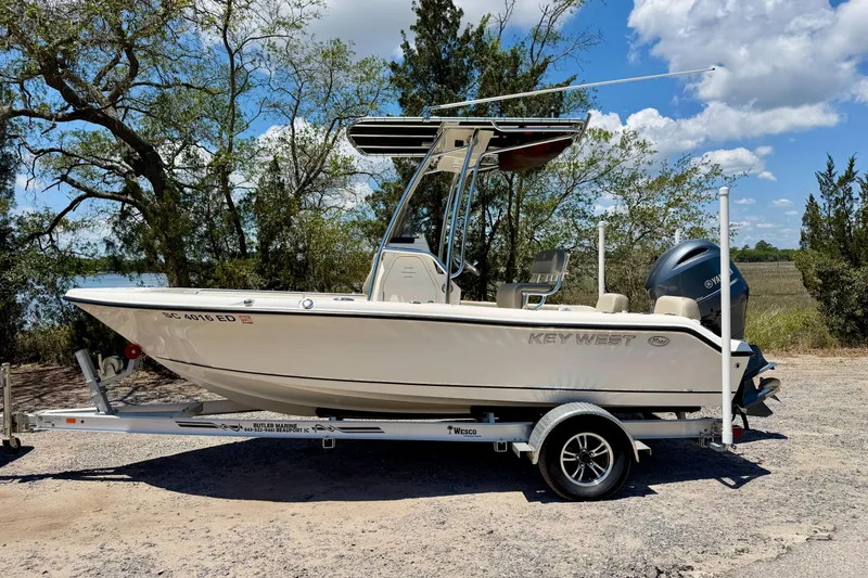 Slide: The Image of 2023 Key West 189 FS boat on trailer, parked outdoors under a clear blue sky. - 32