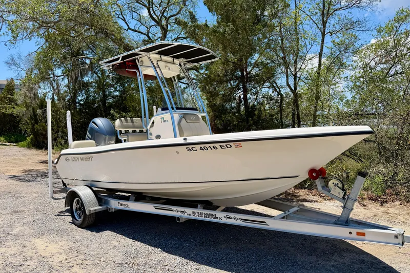 Slide: The Image of 2023 Key West 189 FS boat on trailer, surrounded by trees and blue sky. - 35