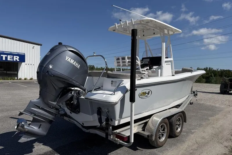 Slide: The Image of 2024 Sea Hunt Ultra 219 boat with Yamaha engine on a trailer, parked outdoors. - 3