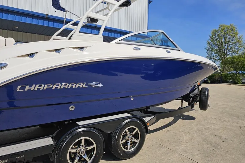 Slide: The Image of 2016 Chaparral 244 Sunesta boat on trailer, blue and white design, sunny day. - 10