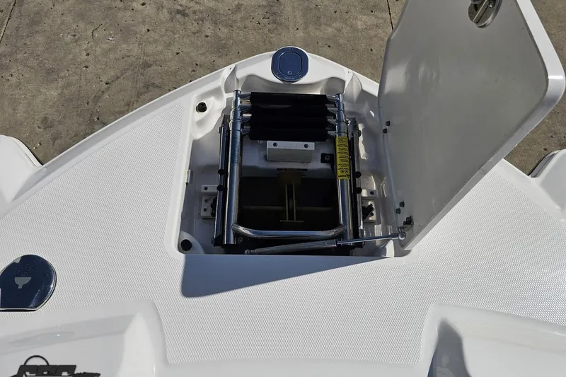 Slide: The Image of 2016 Chaparral 244 Sunesta boat ladder compartment, open on a textured deck surface. - 100