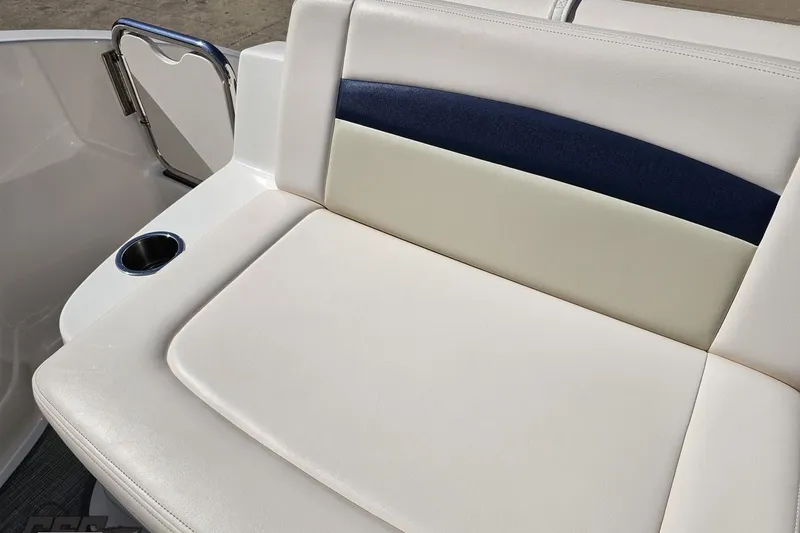 Slide: The Image of 2016 Chaparral 244 Sunesta boat seat with cup holder, featuring white and navy upholstery. - 114
