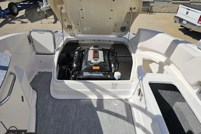 Slide: The Image of 2016 Chaparral 244 Sunesta boat engine compartment with open hatch, showcasing engine details. - 116