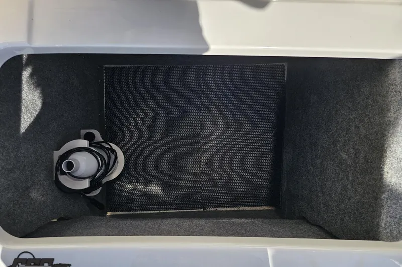 Slide: The Image of Storage compartment in 2016 Chaparral 244 Sunesta boat, featuring a coiled cable. - 117