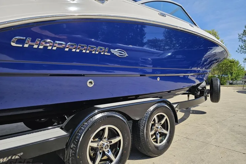 Slide: The Image of 2016 Chaparral 244 Sunesta boat on trailer, featuring sleek blue hull design. - 13