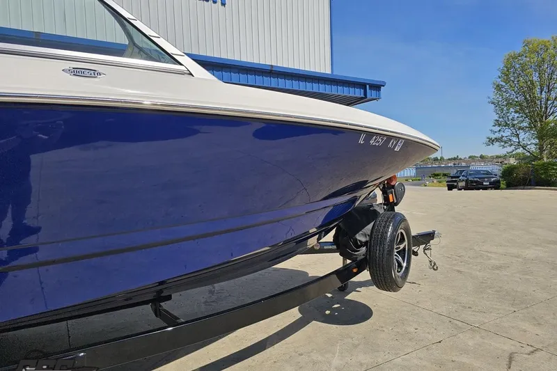 Slide: The Image of 2016 Chaparral 244 Sunesta boat on trailer, blue hull, parked outdoors. - 14
