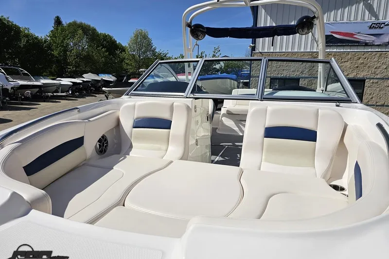 Slide: The Image of 2016 Chaparral 244 Sunesta boat with spacious seating and sleek design in a sunny outdoor setting. - 22