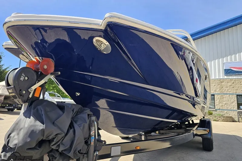 Slide: The Image of 2016 Chaparral 244 Sunesta boat on trailer, blue hull, parked outdoors. - 23