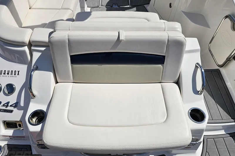 Slide: The Image of 2016 Chaparral 244 Sunesta boat interior with white cushioned seating and cup holders. - 44