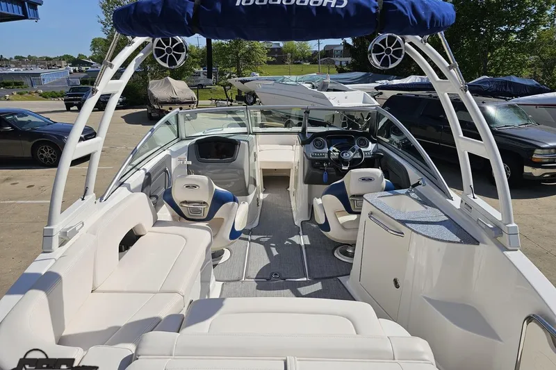 Slide: The Image of 2016 Chaparral 244 Sunesta boat interior with seating and steering console, docked outdoors. - 49