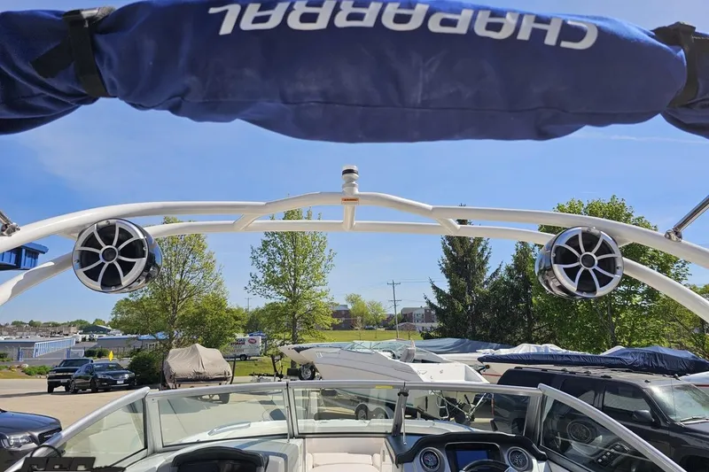 Slide: The Image of 2016 Chaparral 244 Sunesta boat with speakers and canopy, parked outdoors on a sunny day. - 57