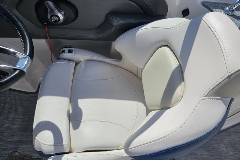 Slide: The Image of 2016 Chaparral 244 Sunesta boat seat with white upholstery and steering wheel detail. - 67