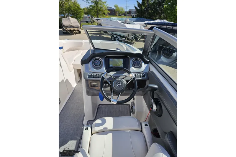 Slide: The Image of 2016 Chaparral 244 Sunesta boat cockpit with steering wheel and dashboard controls. - 76