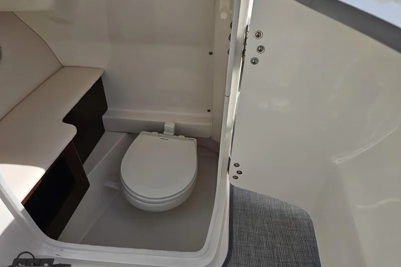 Slide: The Image of Interior of 2016 Chaparral 244 Sunesta boat featuring a compact marine toilet. - 78