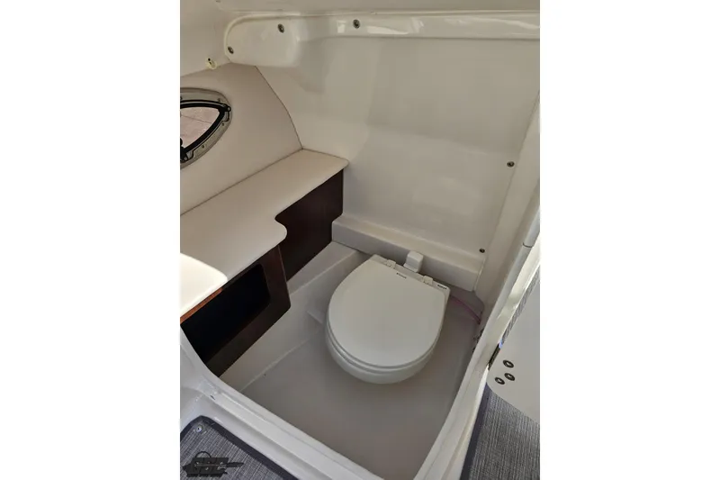 Slide: The Image of 2016 Chaparral 244 Sunesta boat interior with compact marine toilet and storage space. - 79