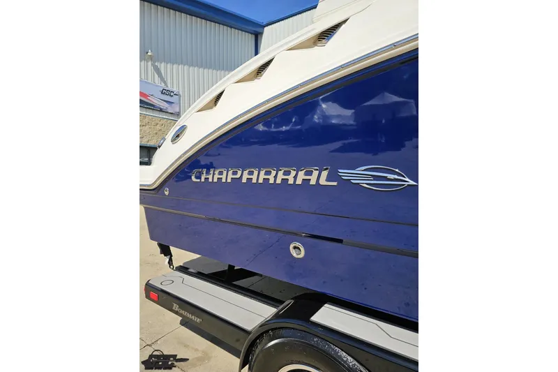 Slide: The Image of 2016 Chaparral 244 Sunesta boat, blue exterior, displayed on a trailer. - 8