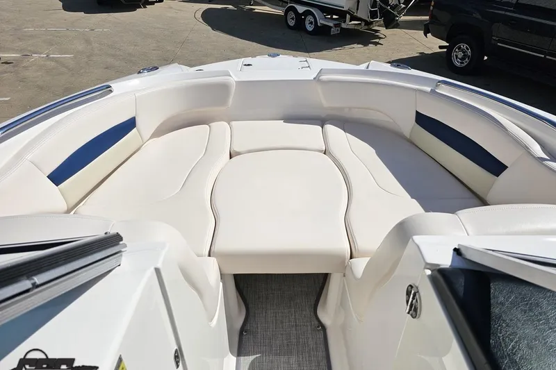 Slide: The Image of 2016 Chaparral 244 Sunesta boat interior with spacious white seating and blue accents. - 86