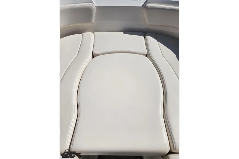 Slide: The Image of 2016 Chaparral 244 Sunesta boat interior seating, featuring beige cushioned upholstery. - 89