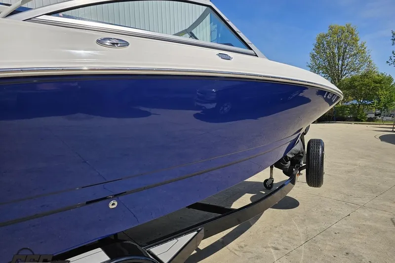 Slide: The Image of 2016 Chaparral 244 Sunesta boat on trailer, blue hull, sunny day. - 9