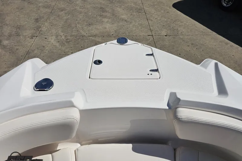 Slide: The Image of 2016 Chaparral 244 Sunesta boat bow with white seating and storage compartment. - 94