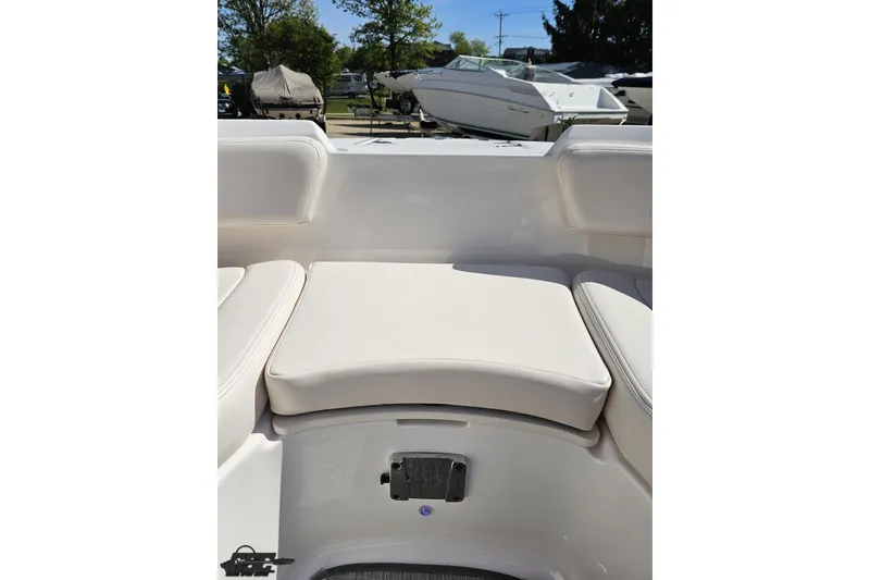 Slide: The Image of 2016 Chaparral 244 Sunesta boat interior seating, featuring white cushioned seats and sleek design. - 97