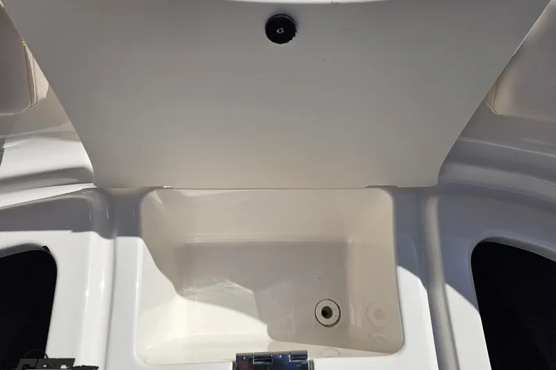 Slide: The Image of Storage compartment of a 2016 Chaparral 244 Sunesta boat, featuring a clean, white interior. - 99